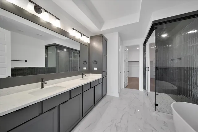 a spacious bathroom with a bathtub shower sink mirror and toilet