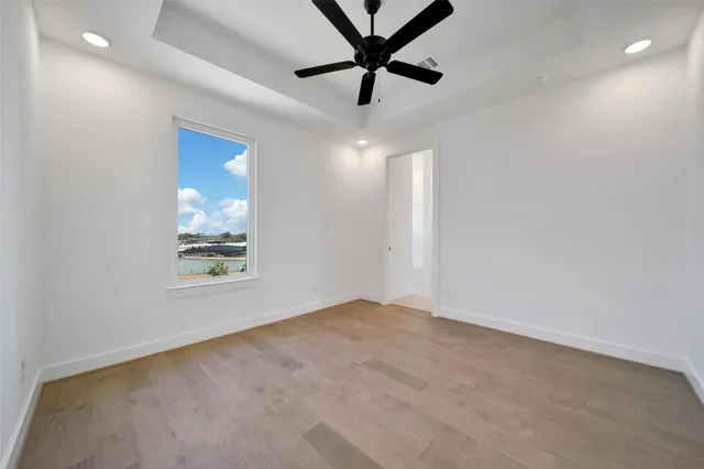an empty room with windows and fan