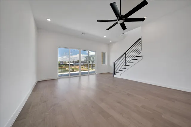 a view of room with wooden floor and ceiling fan