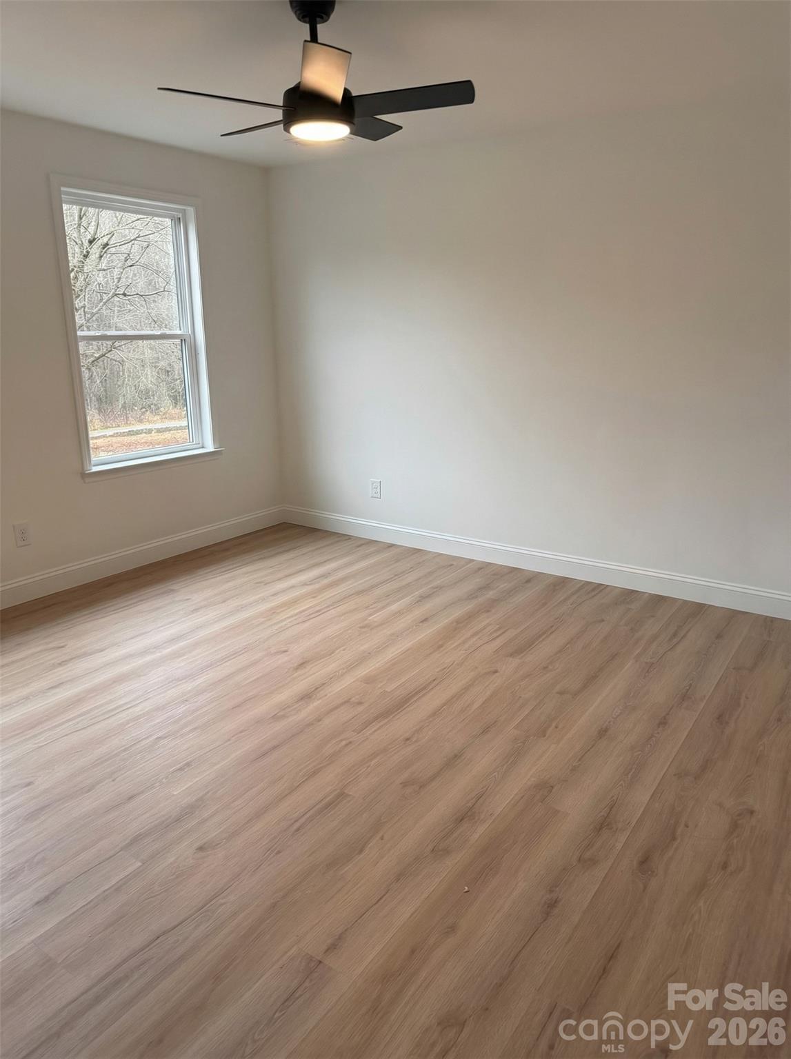 2170 Neel Road Salisbury, NC 28147 - Photo 16 of 21 an empty room with wooden floor chandelier fan and windows