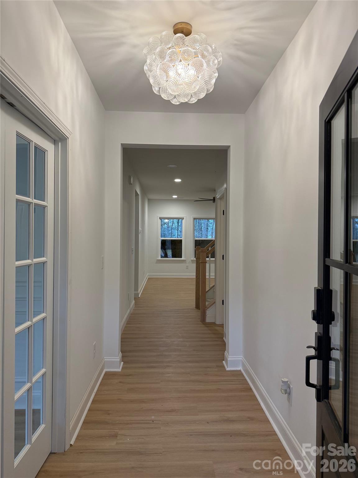2170 Neel Road Salisbury, NC 28147 - Photo 3 of 21 a view of a hallway to a livingroom with wooden floor and a chandelier