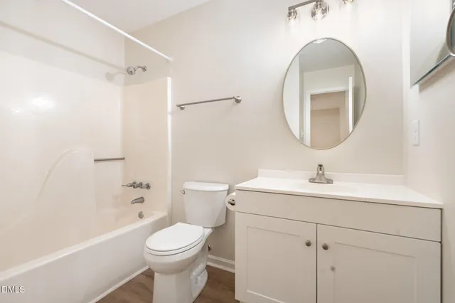 an empty room with wooden floor cabinet and windows
