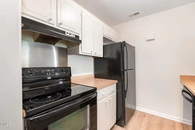 a kitchen with granite countertop white cabinets and a sink