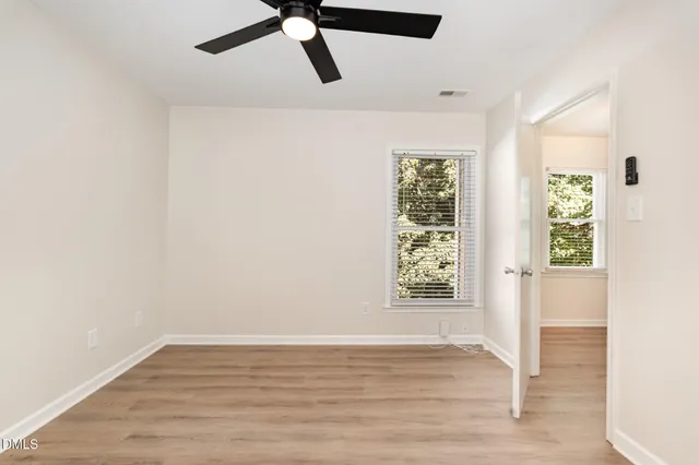 a view of a room with wooden floor and windows