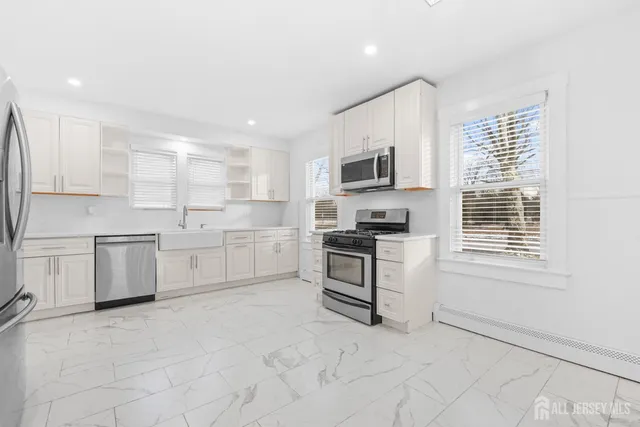 a kitchen with white cabinets and appliances