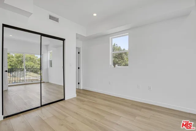 a kitchen with stainless steel appliances granite countertop a sink a stove a refrigerator cabinets and a window