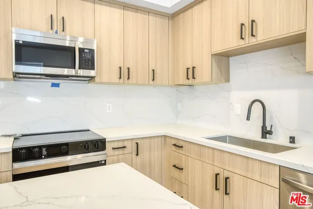 a view of a kitchen with a sink and wooden floor