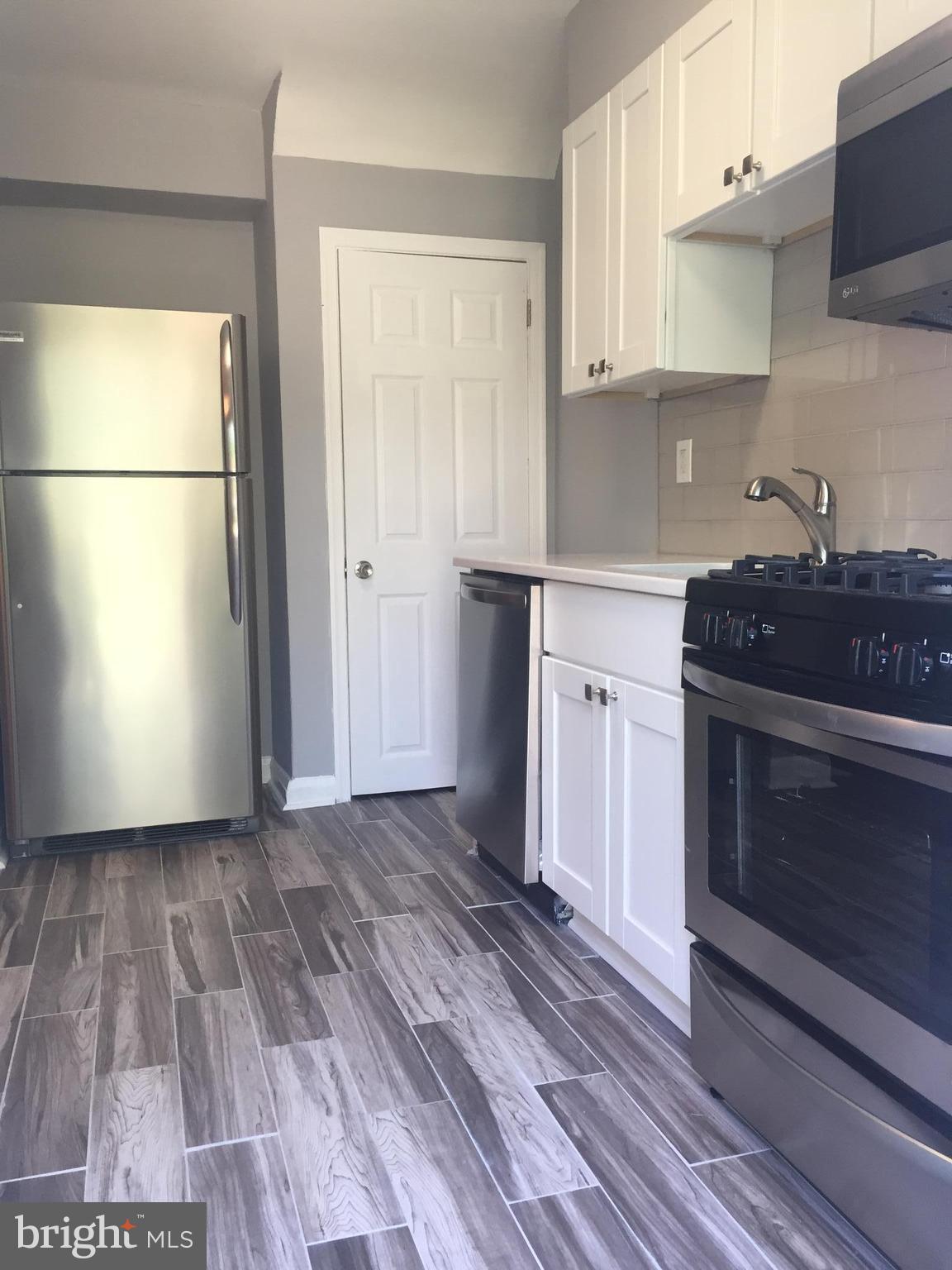 1928 Jasmine Road Dundalk, MD 21222 - Photo 3 of 30 a kitchen with wooden floors and a sink