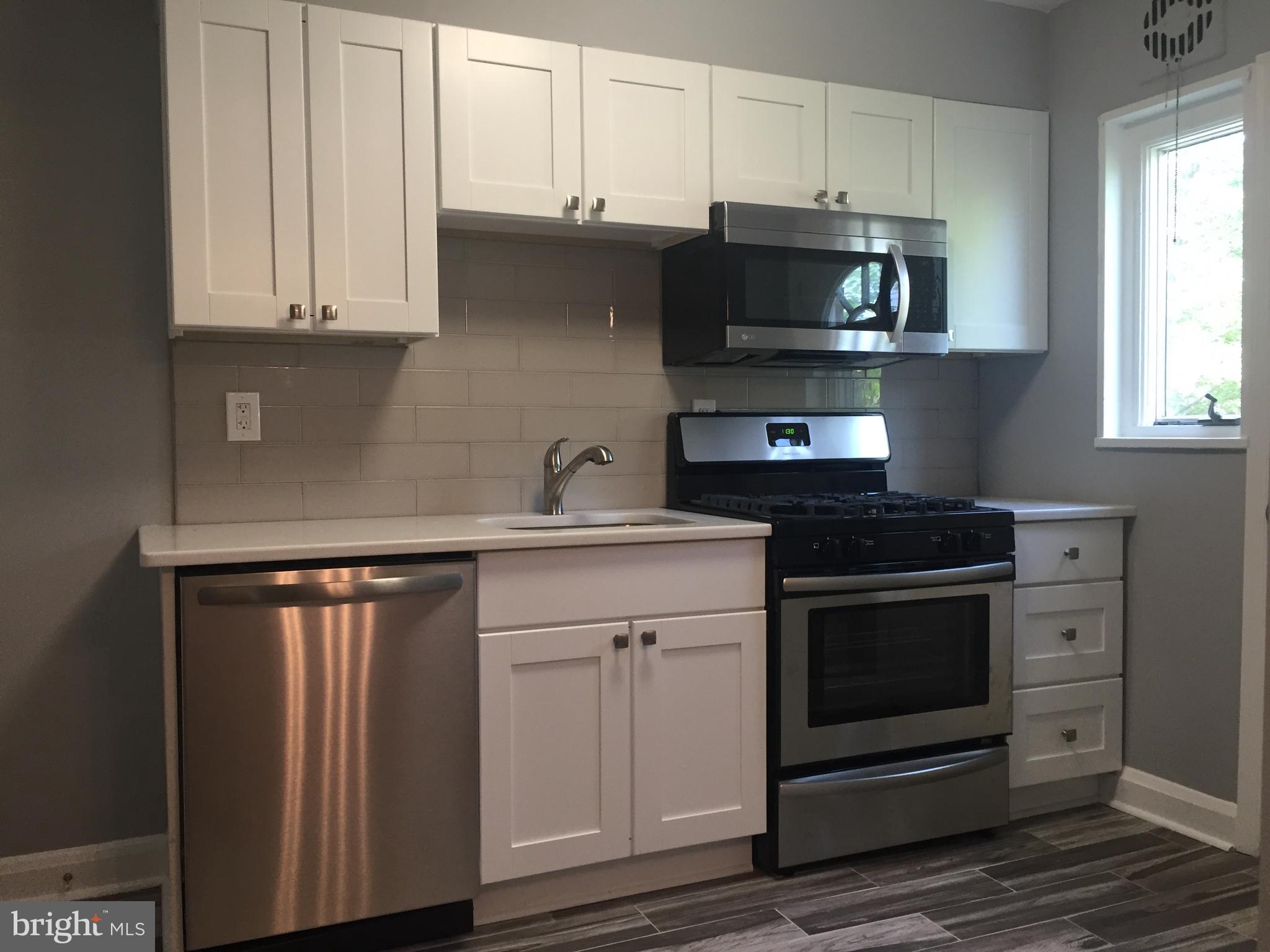 1928 Jasmine Road Dundalk, MD 21222 - Photo 5 of 30 a kitchen with stainless steel appliances granite countertop a stove and a microwave