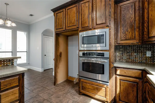 a kitchen with granite countertop a stove cabinets and microwave