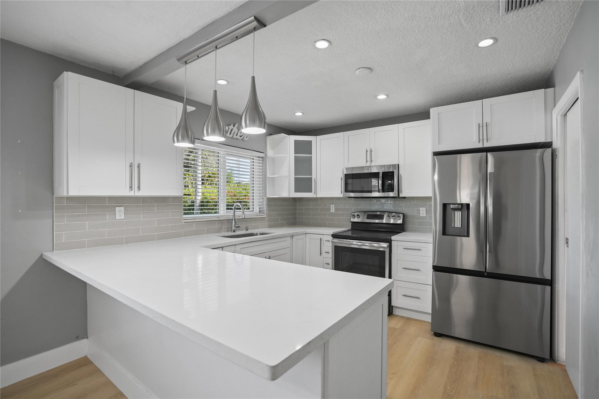 8930 Southwest 38th Street Miami, FL 33165 - Photo 4 of 16 a kitchen with granite countertop a refrigerator a sink dishwasher a stove top oven a refrigerator and cabinets