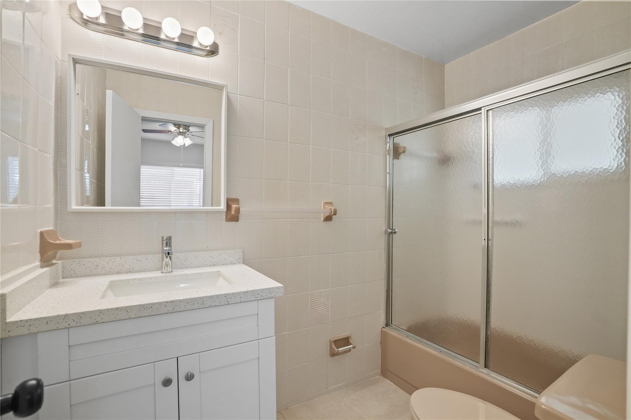 8930 Southwest 38th Street Miami, FL 33165 - Photo 10 of 16 a bathroom with a shower sink vanity mirror and toilet