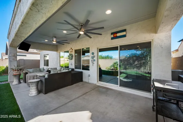a living room with furniture a flat screen tv and a floor to ceiling window