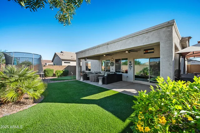 a view of a patio with table and chairs potted plants and large tree