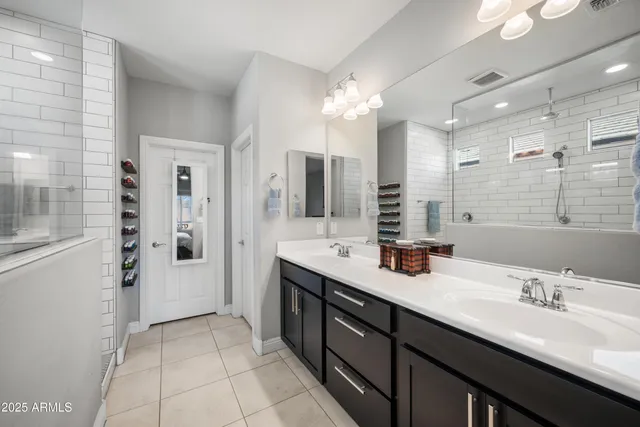 a bathroom with a double vanity sink mirror and shower