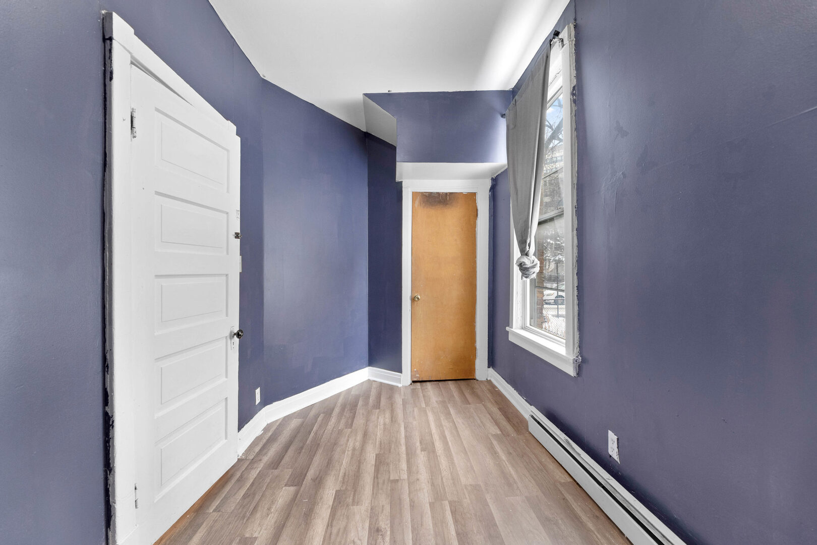 6124 South Sangamon Street Chicago, IL 60621 - Photo 12 of 17 a view of an empty room with wooden floor and a window