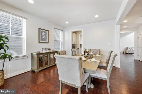 a dining room with a table chairs and kitchen view
