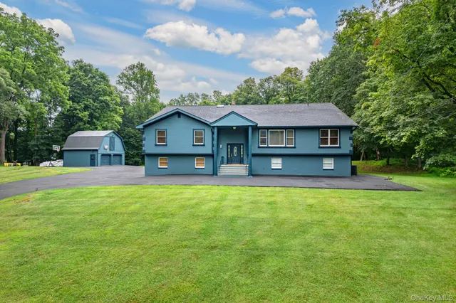 a front view of a house with yard and green space