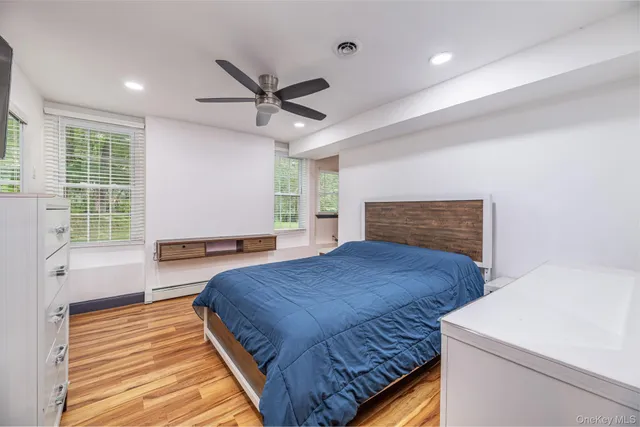 a bedroom with furniture wooden floor and window