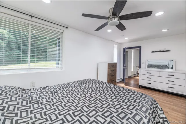 a bathroom with a granite countertop sink a toilet a mirror and shower