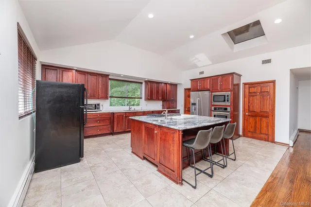 a kitchen with stainless steel appliances granite countertop a stove refrigerator and a sink