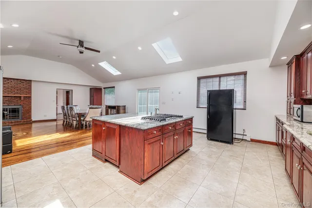 a large kitchen with stainless steel appliances granite countertop a large counter top and a refrigerator