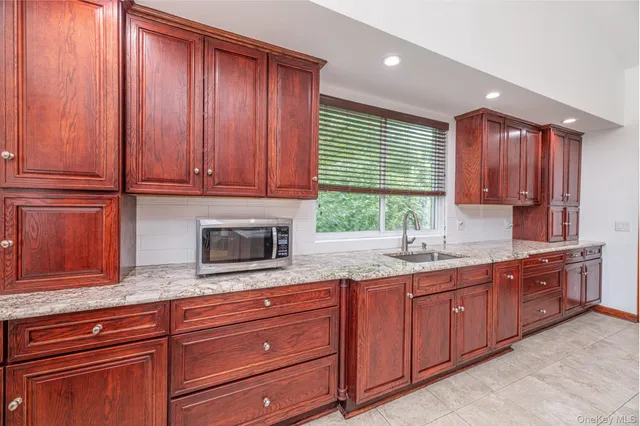 a kitchen with granite countertop wooden cabinets stainless steel appliances a sink and window