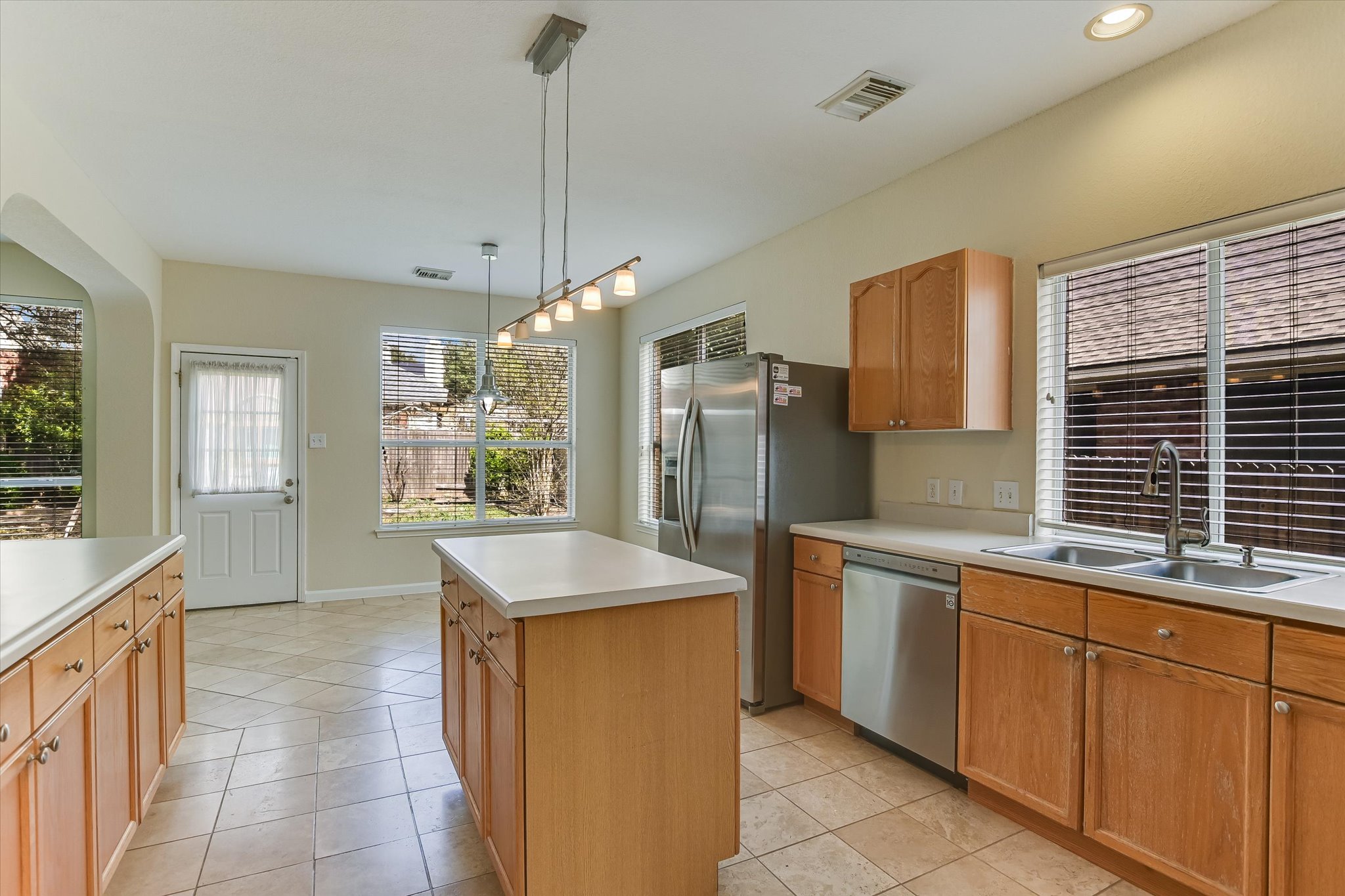 2218 Equestrian Trail Austin, TX 78727 - Photo 16 of 39 Kitchen featuring light countertops, stainless steel dishwasher, and light tile patterned floors