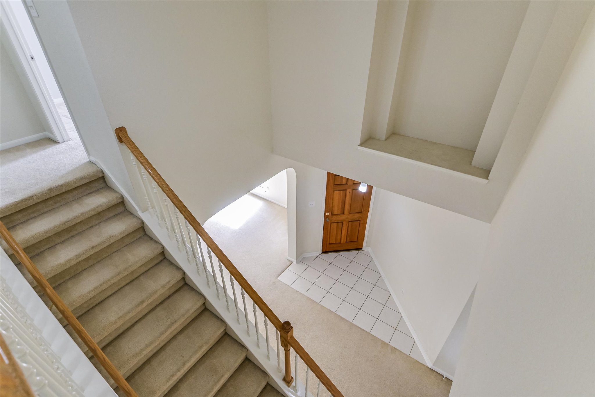2218 Equestrian Trail Austin, TX 78727 - Photo 23 of 39 Staircase featuring carpet, a high ceiling, arched walkways, and tile patterned flooring