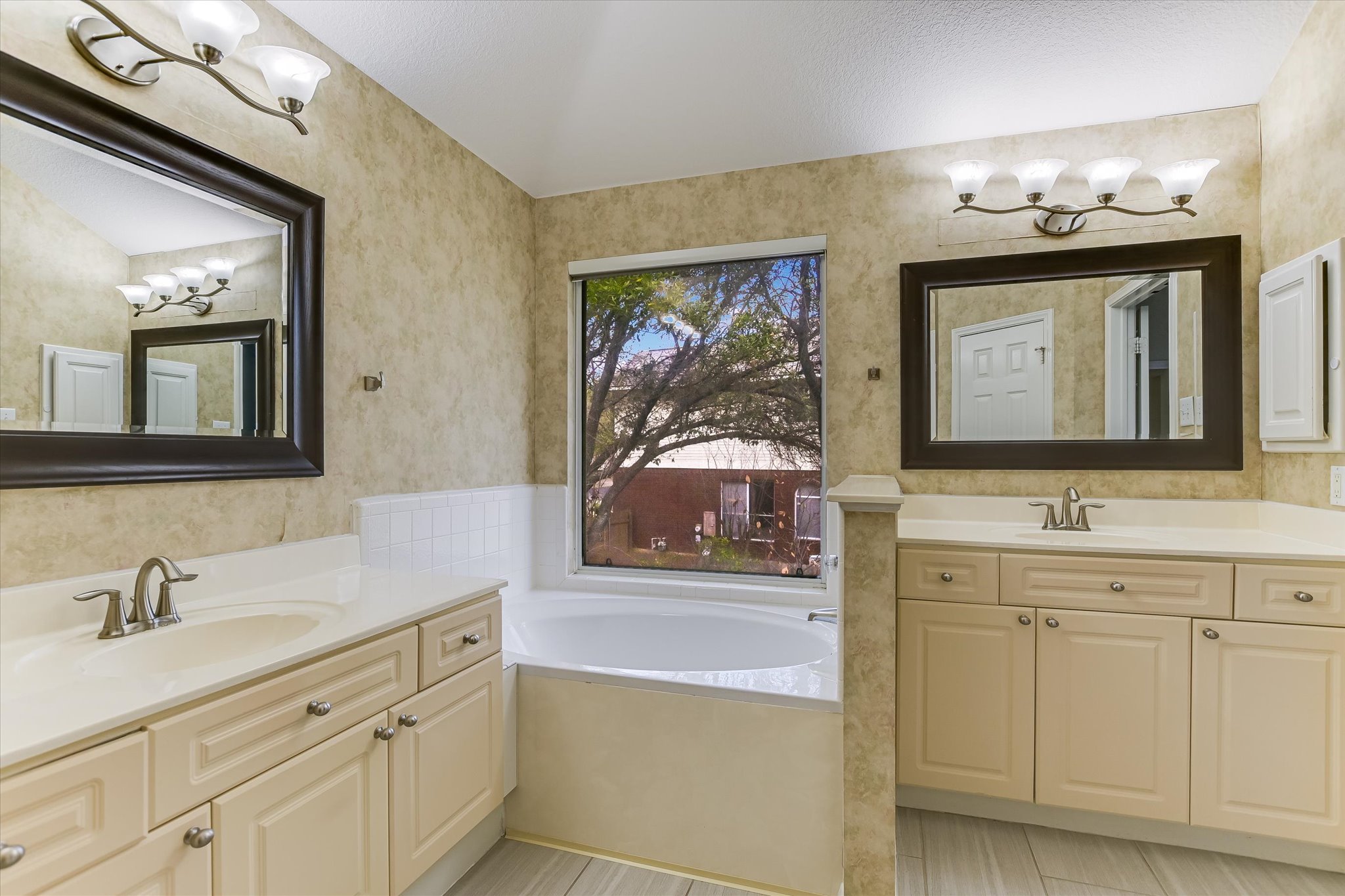 2218 Equestrian Trail Austin, TX 78727 - Photo 28 of 39 Full bath with two vanities, a garden tub, and wallpapered walls