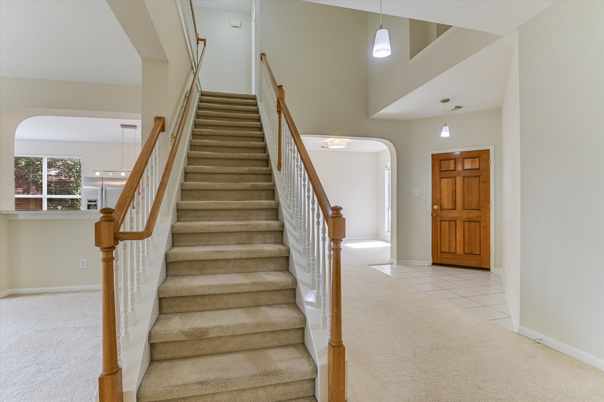2218 Equestrian Trail Austin, TX 78727 - Photo 3 of 39 Staircase featuring carpet floors, arched walkways, and a high ceiling