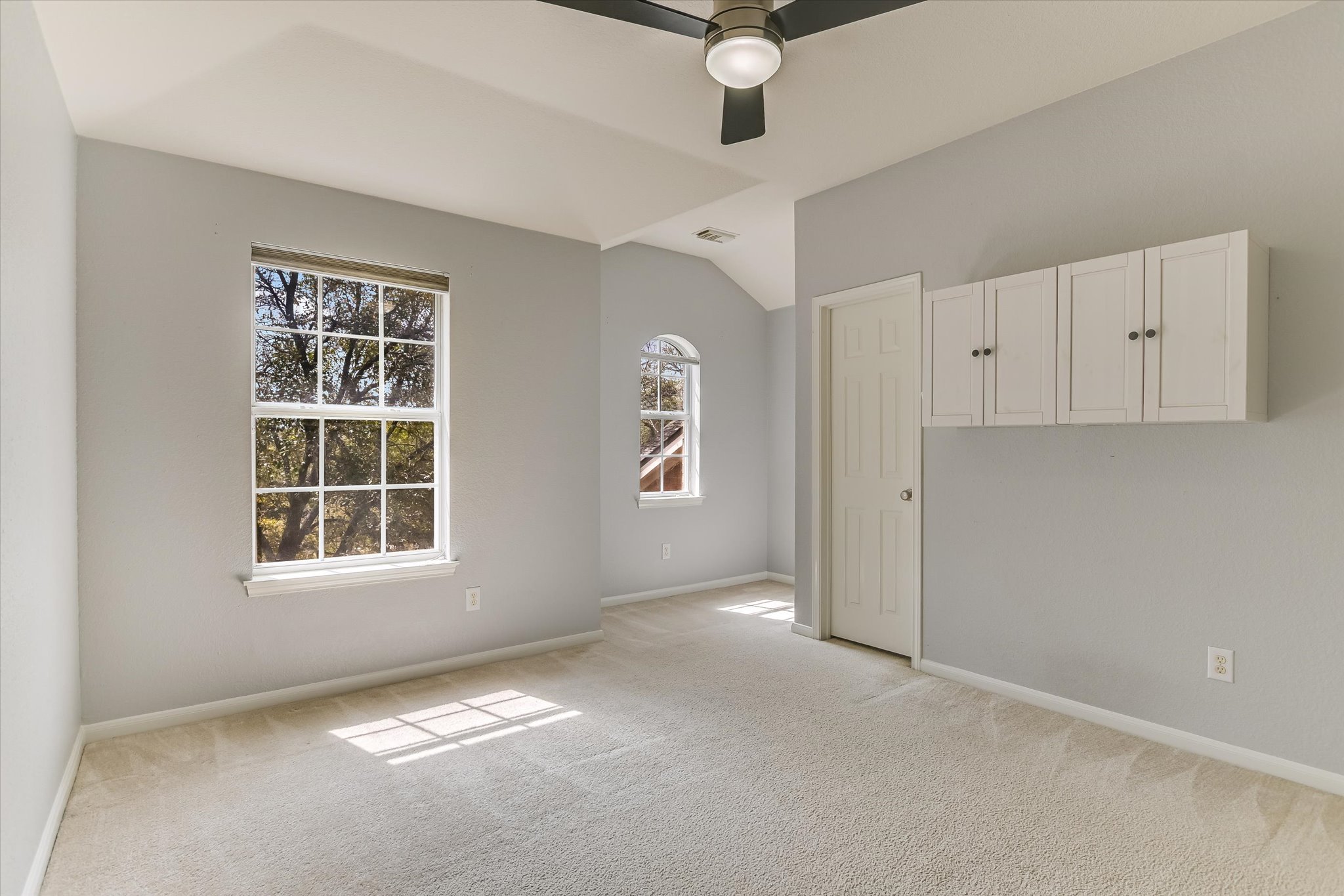 2218 Equestrian Trail Austin, TX 78727 - Photo 31 of 39 Empty room featuring light colored carpet, a ceiling fan, and lofted ceiling