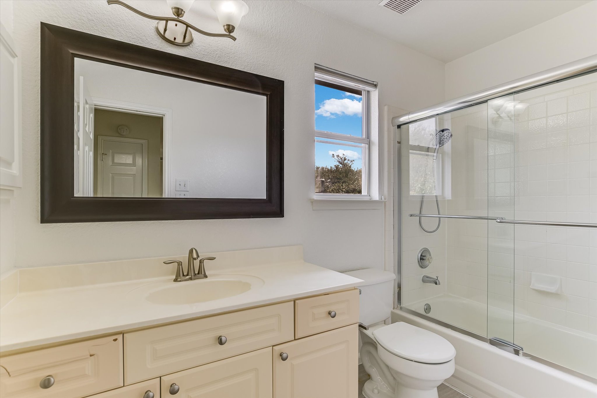 2218 Equestrian Trail Austin, TX 78727 - Photo 32 of 39 Bathroom featuring vanity and bath / shower combo with glass door