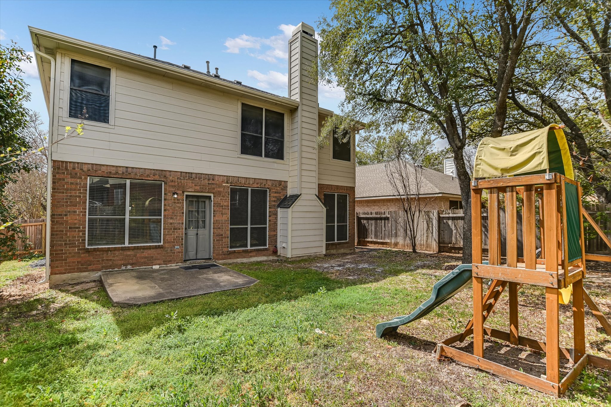 2218 Equestrian Trail Austin, TX 78727 - Photo 39 of 39 Rear view of house with brick siding, a playground, a chimney, and a patio area