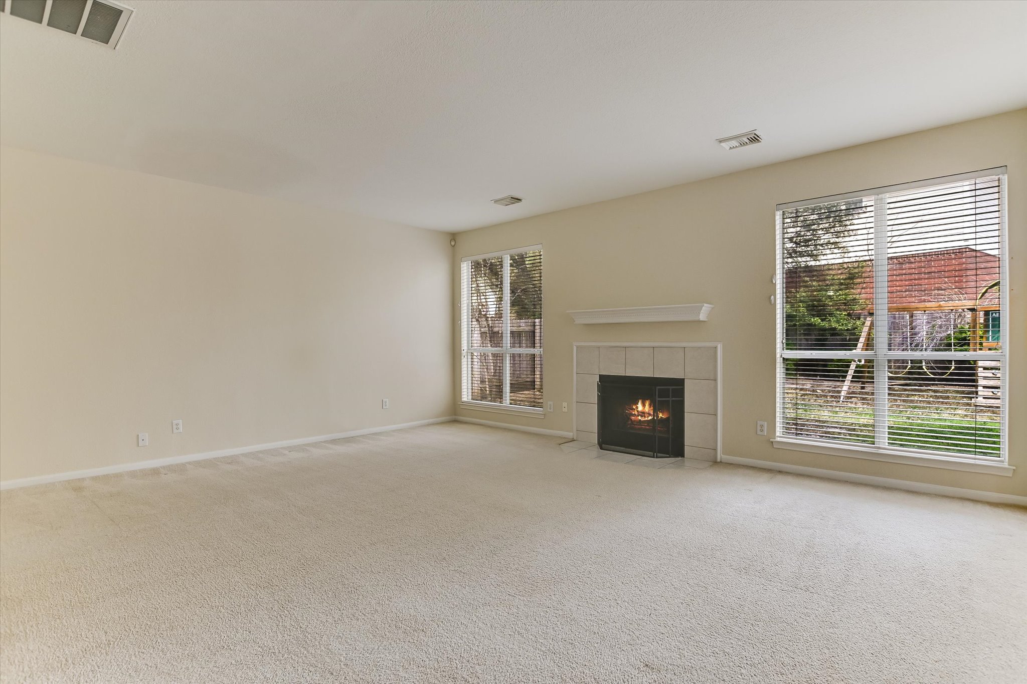 2218 Equestrian Trail Austin, TX 78727 - Photo 8 of 39 Unfurnished living room with plenty of natural light, light colored carpet, and a fireplace