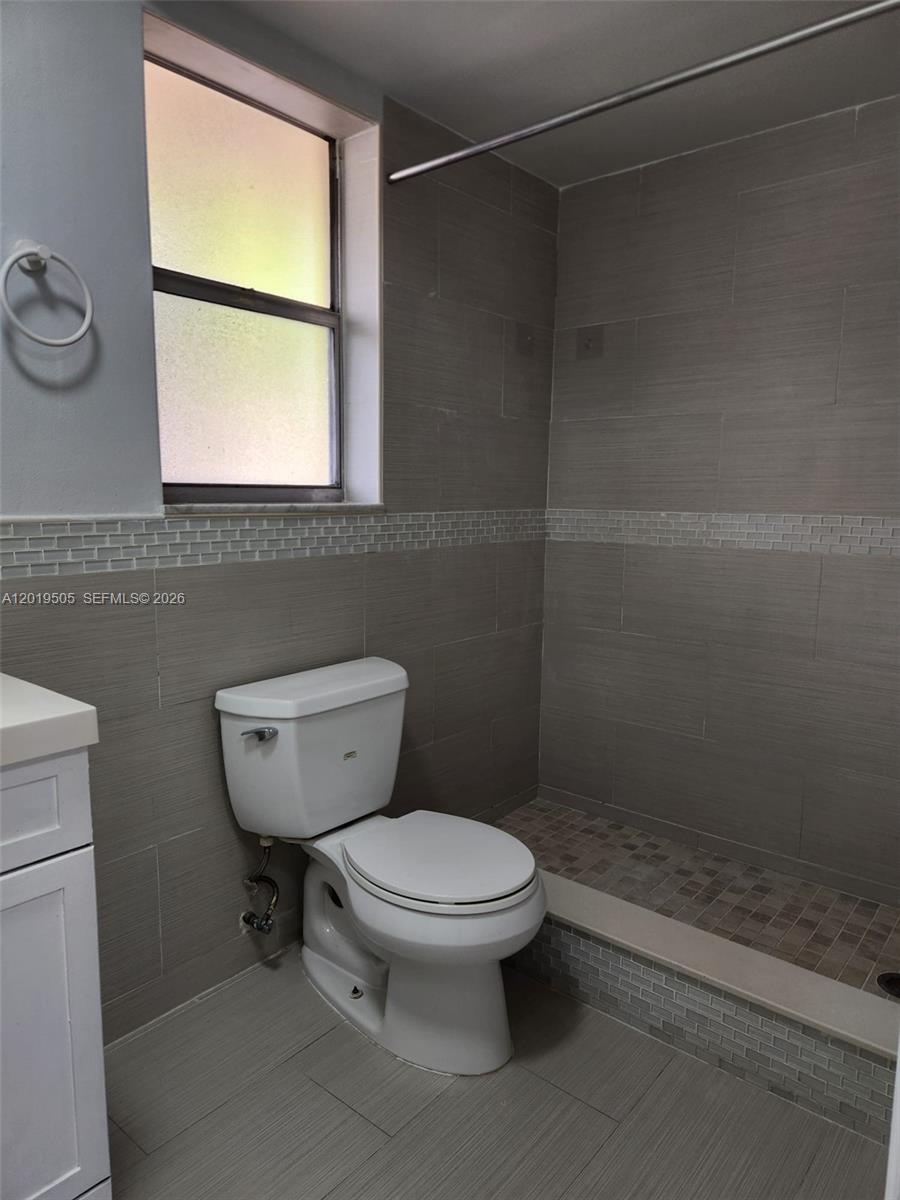 2811 North Pine Island Road, Unit 107 Sunrise, FL 33322 - Photo 9 of 16 a bathroom with a toilet a sink and a shower