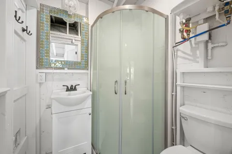 a bathroom with a granite countertop sink toilet and shower