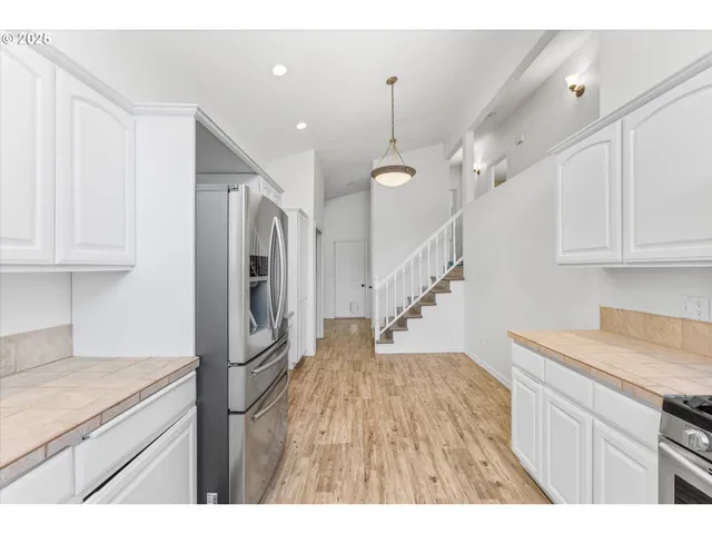 a kitchen with cabinets and wooden floor
