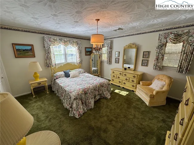 a spacious bedroom with a bed a couch and dresser