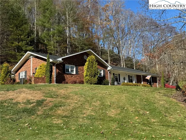 a front view of a house with a yard and trees