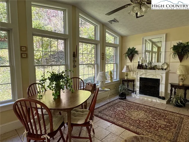 a dining room with furniture a fireplace and wooden floor