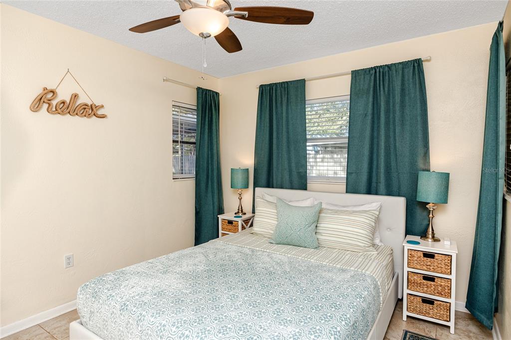 5596 100th Way North St. Petersburg, FL 33708 - Photo 43 of 67 a bedroom with a large bed and a chandelier