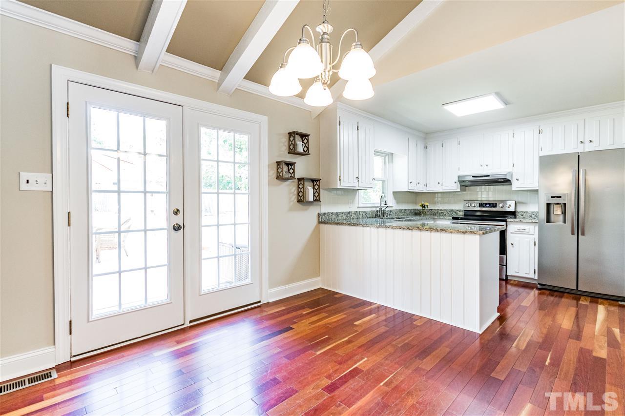 2021 Port Royal Road Raleigh, NC 27609 - Photo 14 of 23 a kitchen with stainless steel appliances granite countertop a refrigerator a sink dishwasher a stove and white countertops with wooden floor