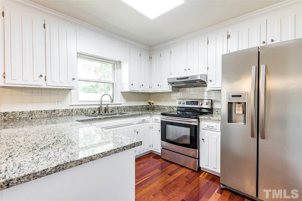2021 Port Royal Road Raleigh, NC 27609 - Photo 16 of 23 a kitchen with granite countertop a refrigerator sink and cabinets