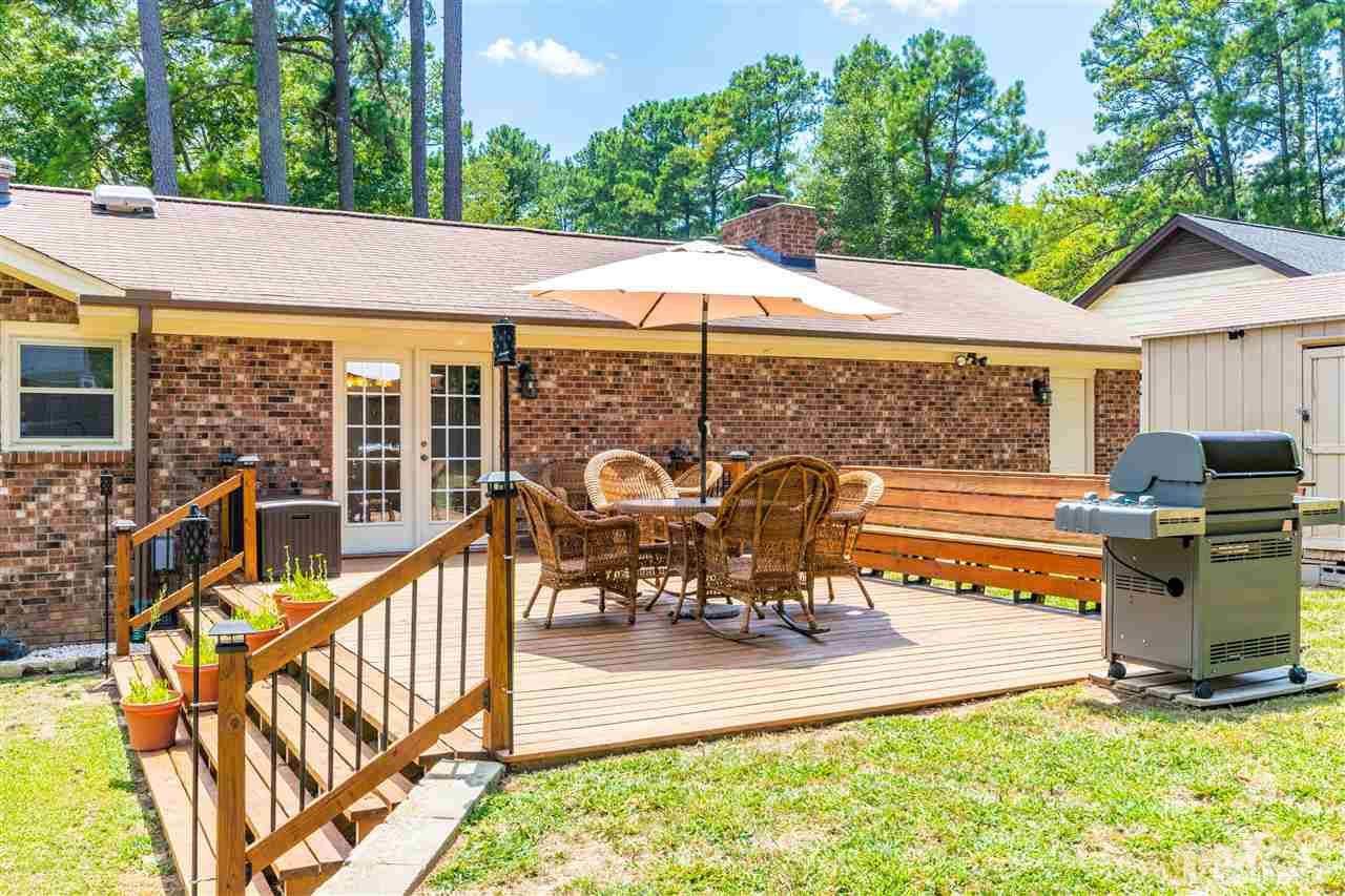 2021 Port Royal Road Raleigh, NC 27609 - Photo 4 of 23 a view of a patio with a table chairs and a floor to ceiling window