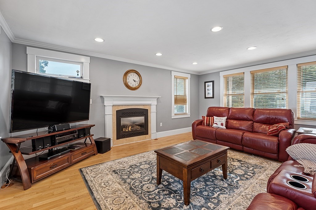 8 Perham Street Chelmsford, MA 01824 - Photo 17 of 42 a living room with furniture a flat screen tv and a fireplace