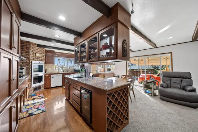 a open kitchen with stainless steel appliances granite countertop a stove and a refrigerator