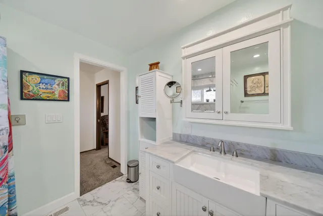 a bathroom with a granite countertop sink mirror and vanity