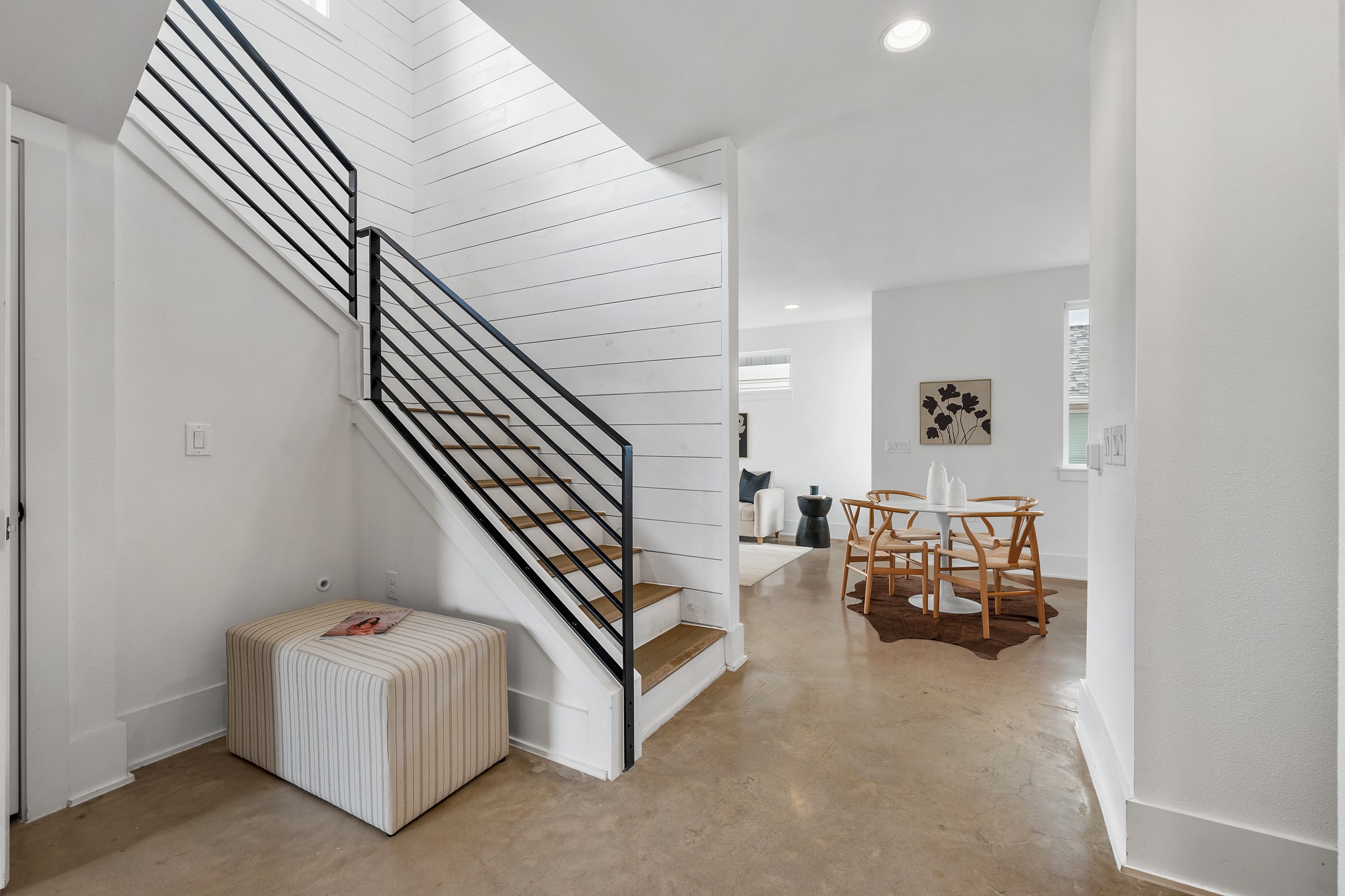 5000 Baker Street Austin, TX 78721 - Photo 11 of 40 Just inside the entry, the staircase features a custom iron railing that adds a striking visual detail while guiding the transition from the main floor up to the bedrooms and balcony above