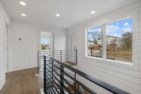 a view of a hallway with wooden floor and a window